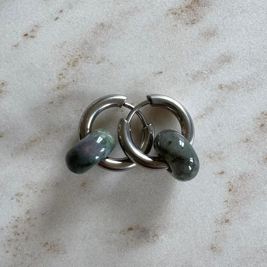 Zwei silbrige Creolen übereinander mit 2 grünen Achat Donut Anhänger auf beigem Marmor