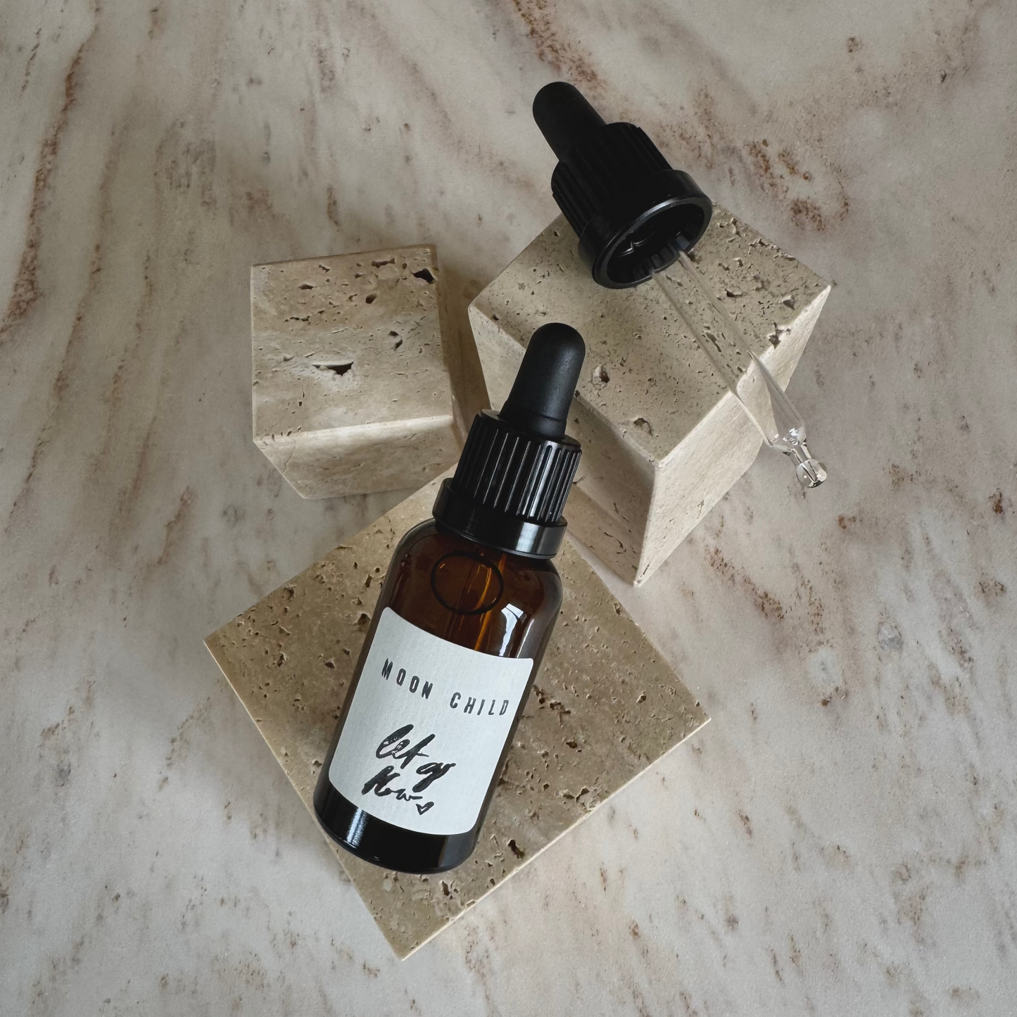 MOndkind Ritualoel in braunem Fläschchen mit Pipette auf beigen Marmor Display
