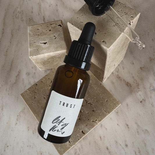 Ritual Oil Trust in brown bottle with Dropper on beige stone display
