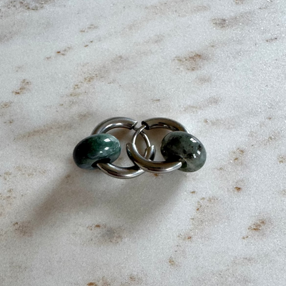 Zwei silbrige Creolen übereinander mit 2 grünen Achat Donut Anhänger auf beigem Marmor