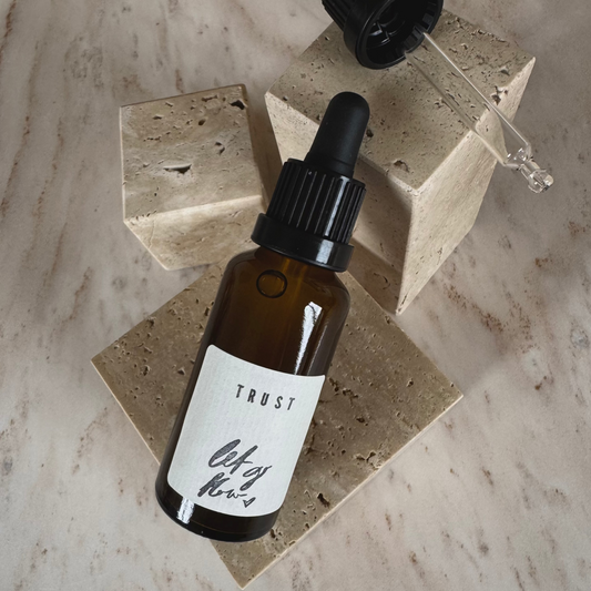 Ritual Oil Trust in brown bottle with Dropper on beige stone display